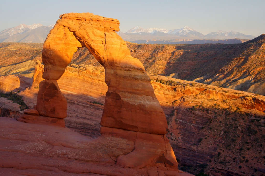 The iconic desert shape, Delicate Arch, in Arches National Park. Sunset with rays moving up the valley.