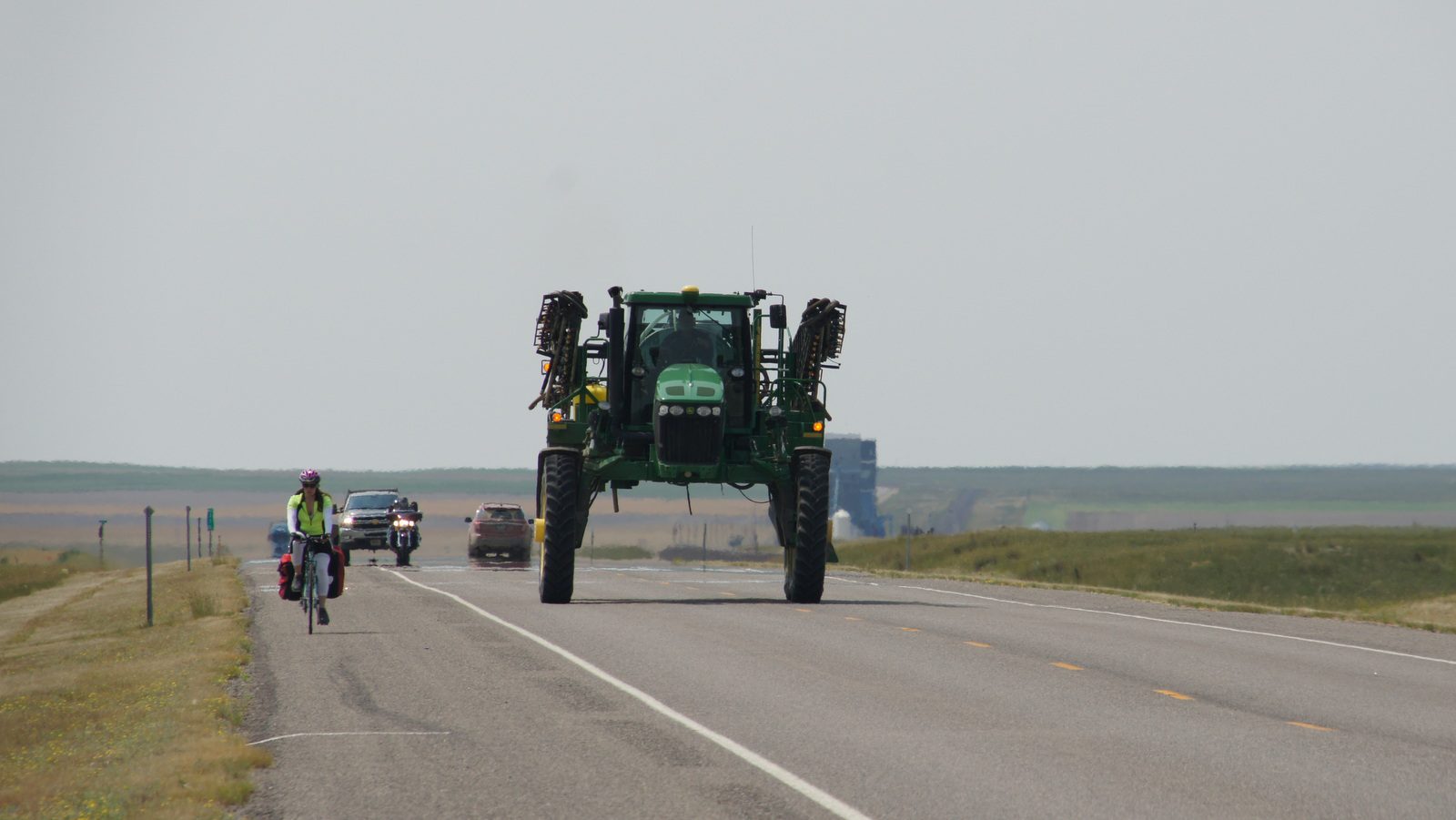 Chelsea and a giant piece of farm machinery share Highway 2 in northern Montana.
