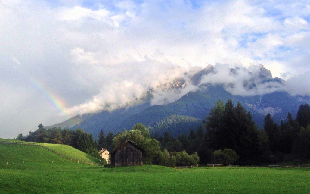 An evening rainbow on the mountains behind Toblach, Italy.